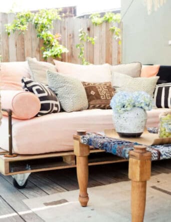 This pallet couch features armrests put together easily from inexpensive pipe found at your local home center.